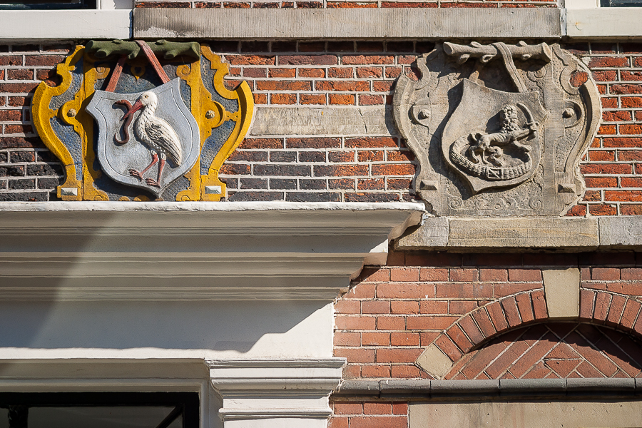 Гербовые изображения на фасаде здания в городе Харлем. Голландия