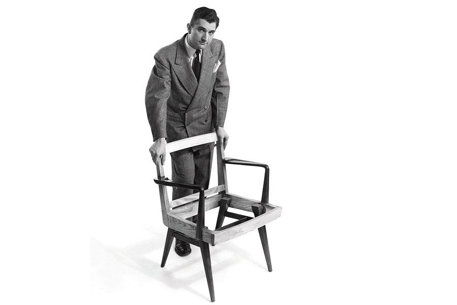 Портрет дизайнера мебели Йенса Рисома, стоящего над незавершенным стулом. Фото: Herbert Matter. 1 июля 1949 г.